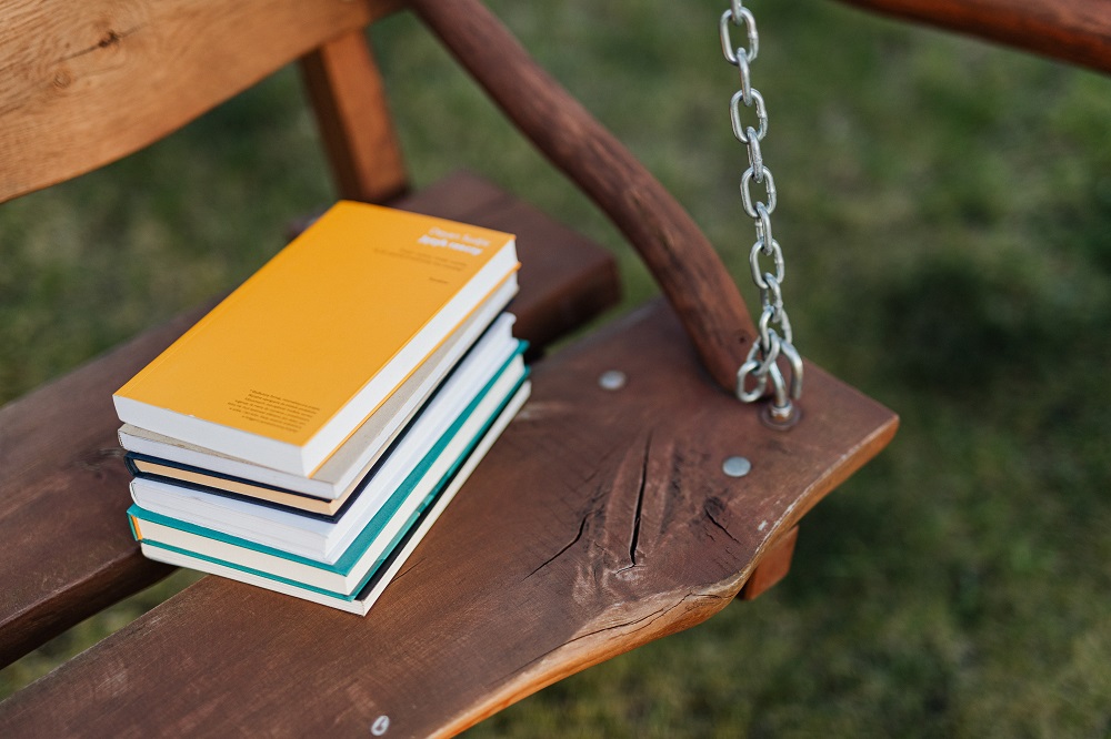 stack of books on a wooden swing seat