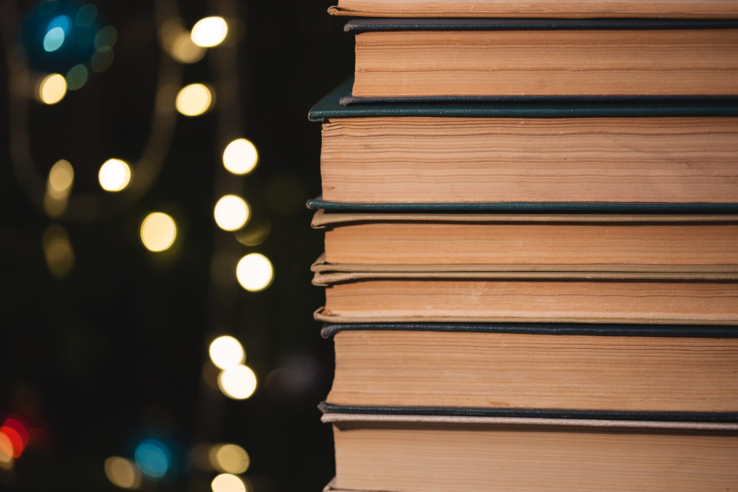 books piled up in front of a christmas tree